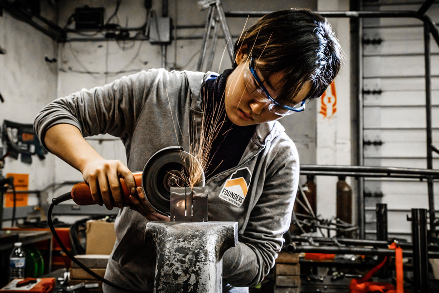 Sparks fly as student uses saw on metal