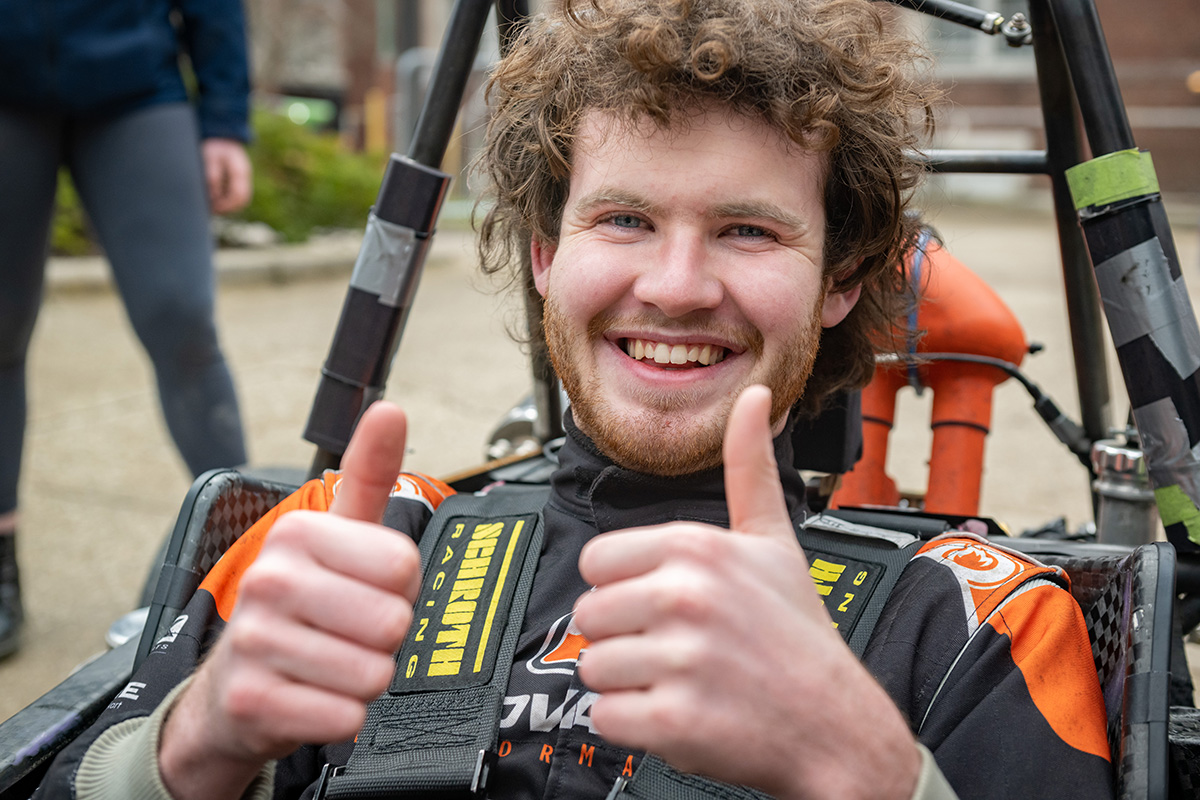 Student in a car with thumbs up